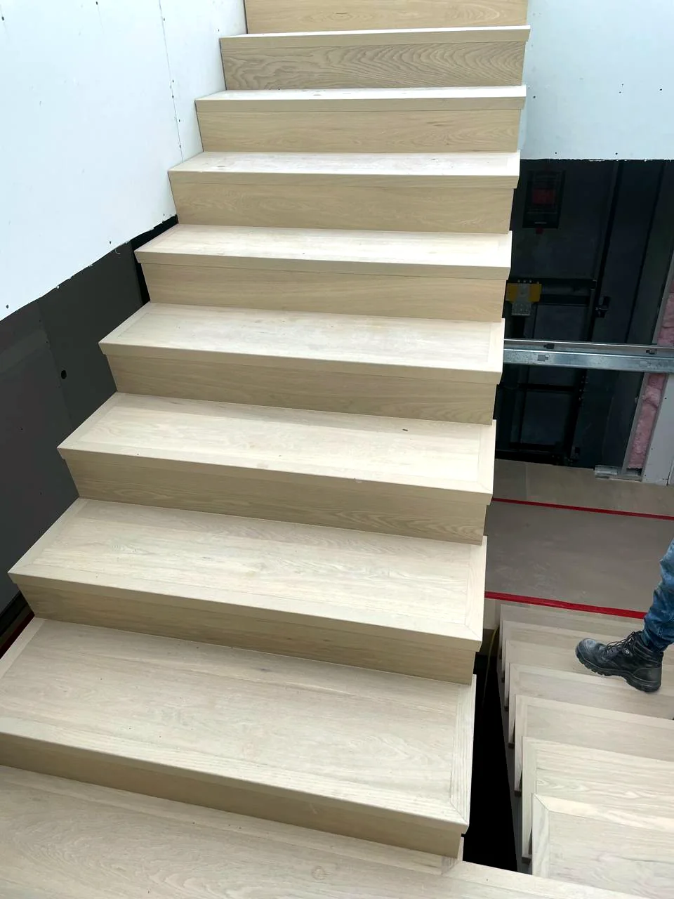 Hardwood stair detail with protected flooring beside it